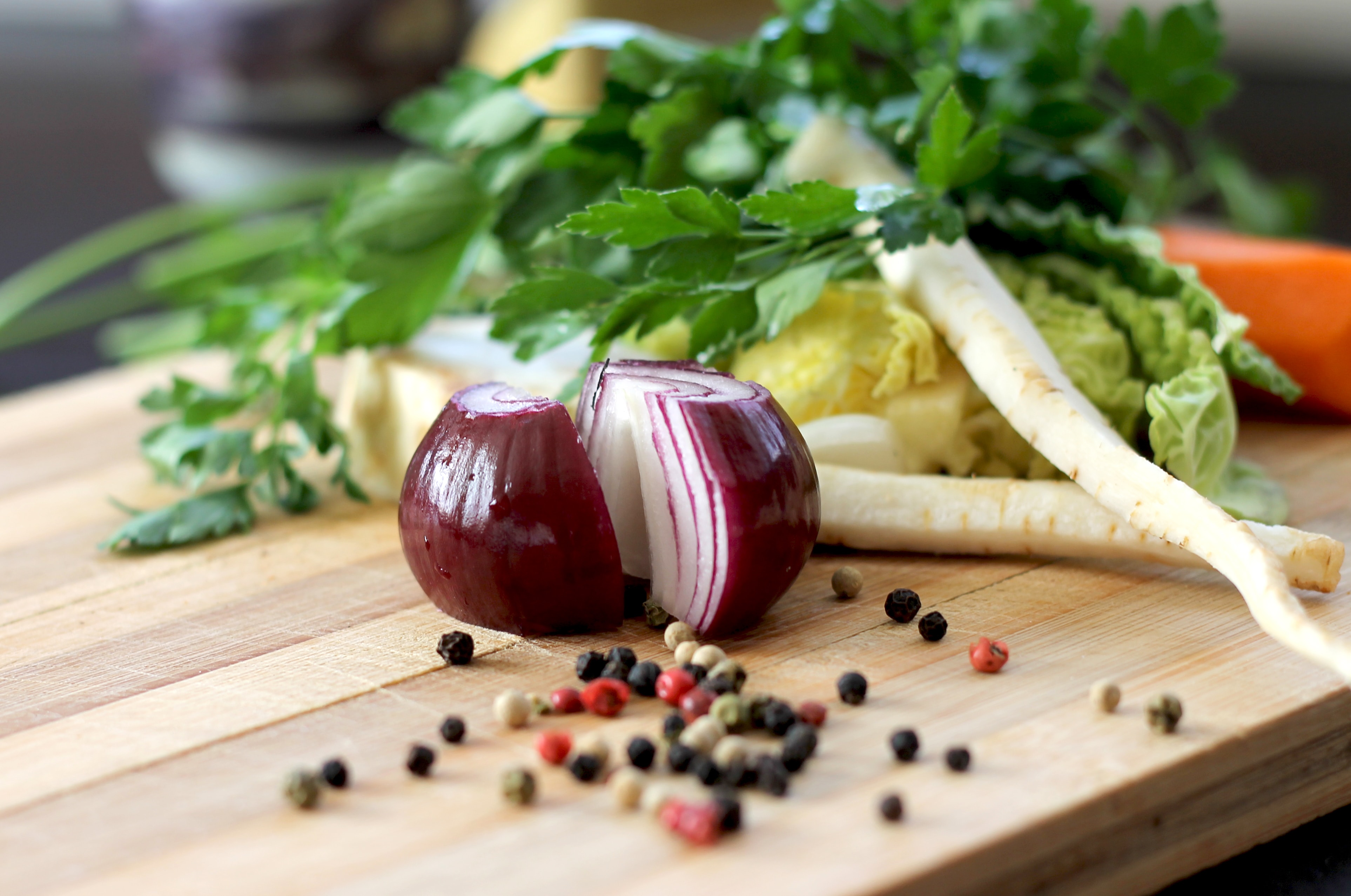 Onion and peppercorns on chopping board